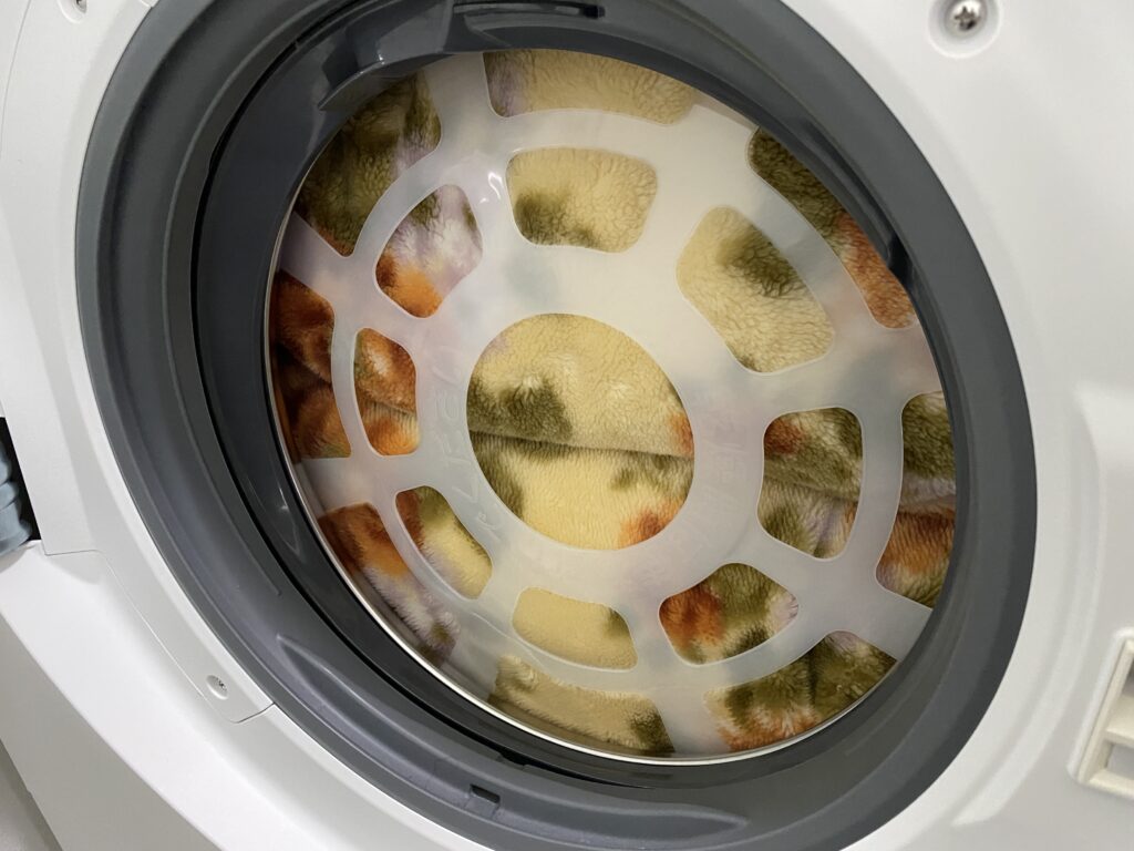 ドラム式洗濯機に毛布を入れて洗濯キャップをセットした写真